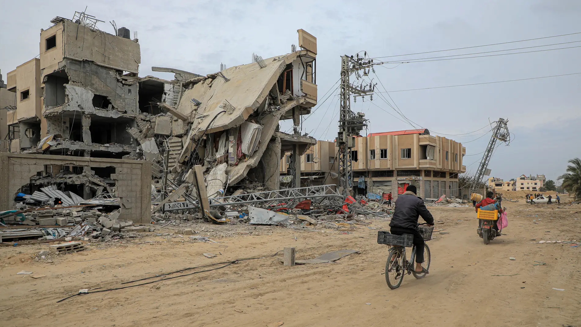  La gente pasa junto a edificios destruidos en los ataques israelíes en la ciudad de Khan Younis, en el sur de la Franja de Gaza
