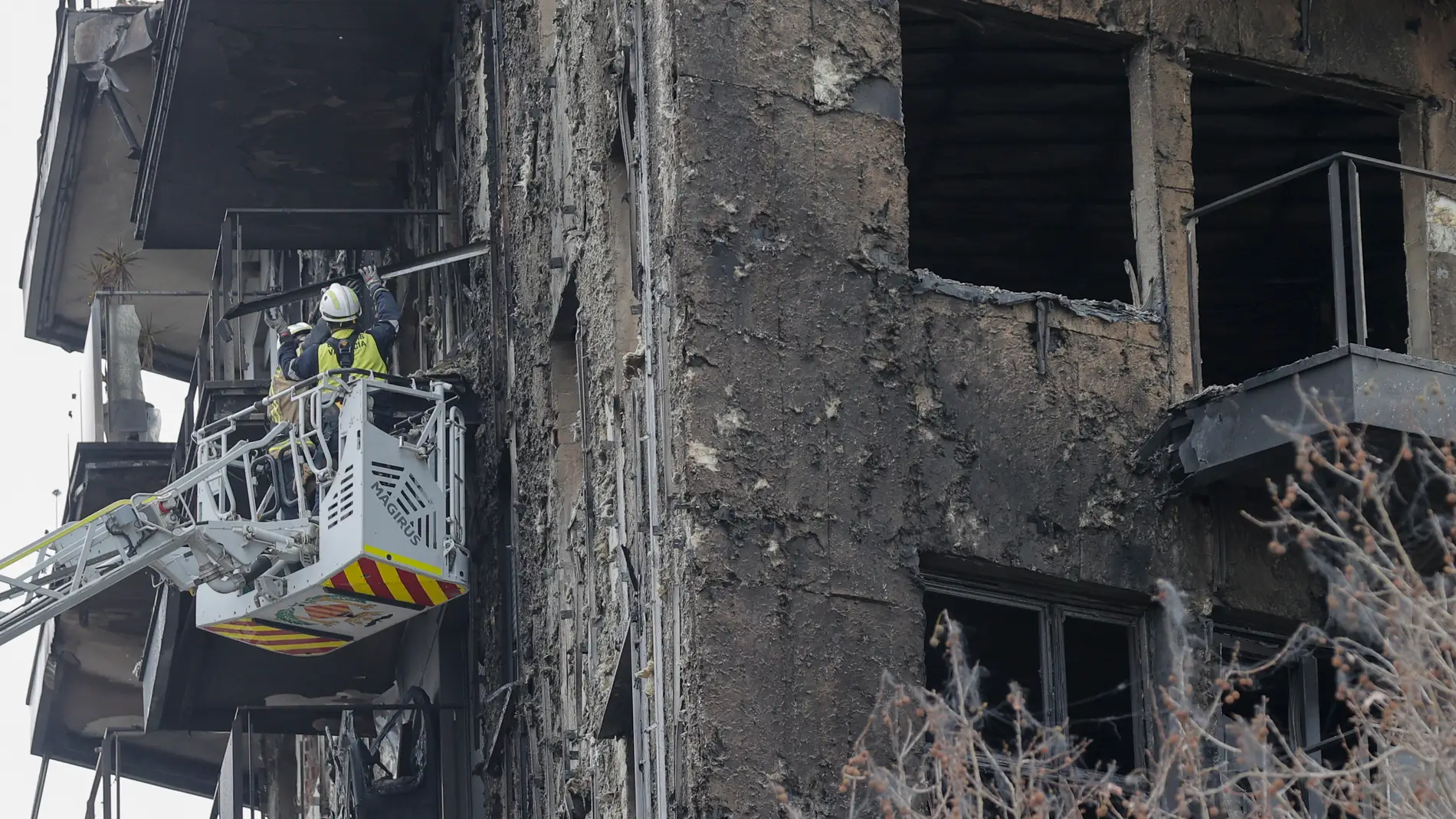 Unos bomberos sanean la fachada del edificio incendiado del barrio valenciano de Campanar, en una imagen de estos días. 