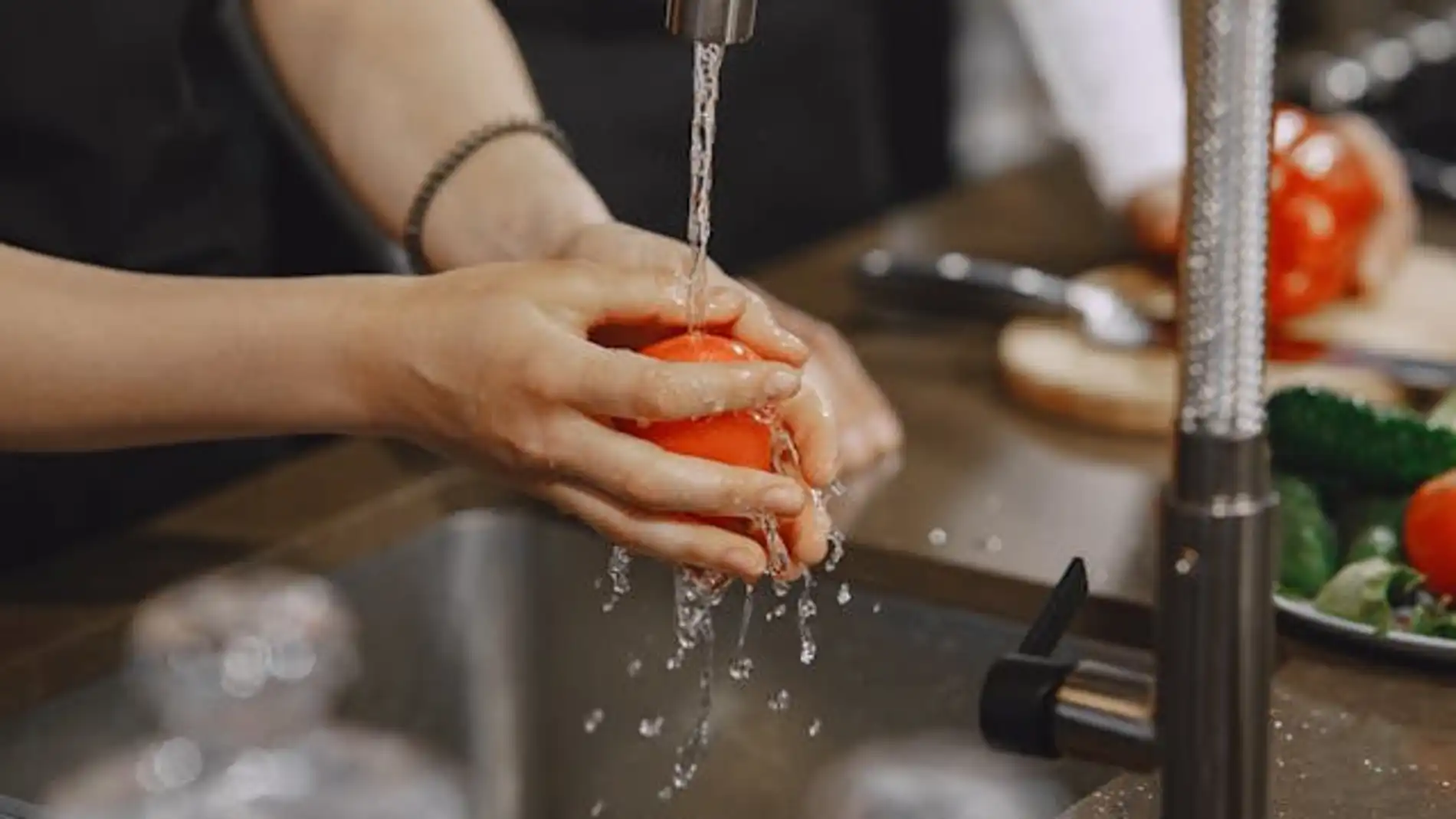 persona lava un tomate
