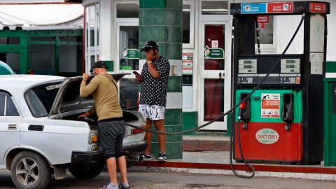 Un hombre abastece de combustible a su vehículo su auto en una estación de gasolina en La Habana (Cuba)