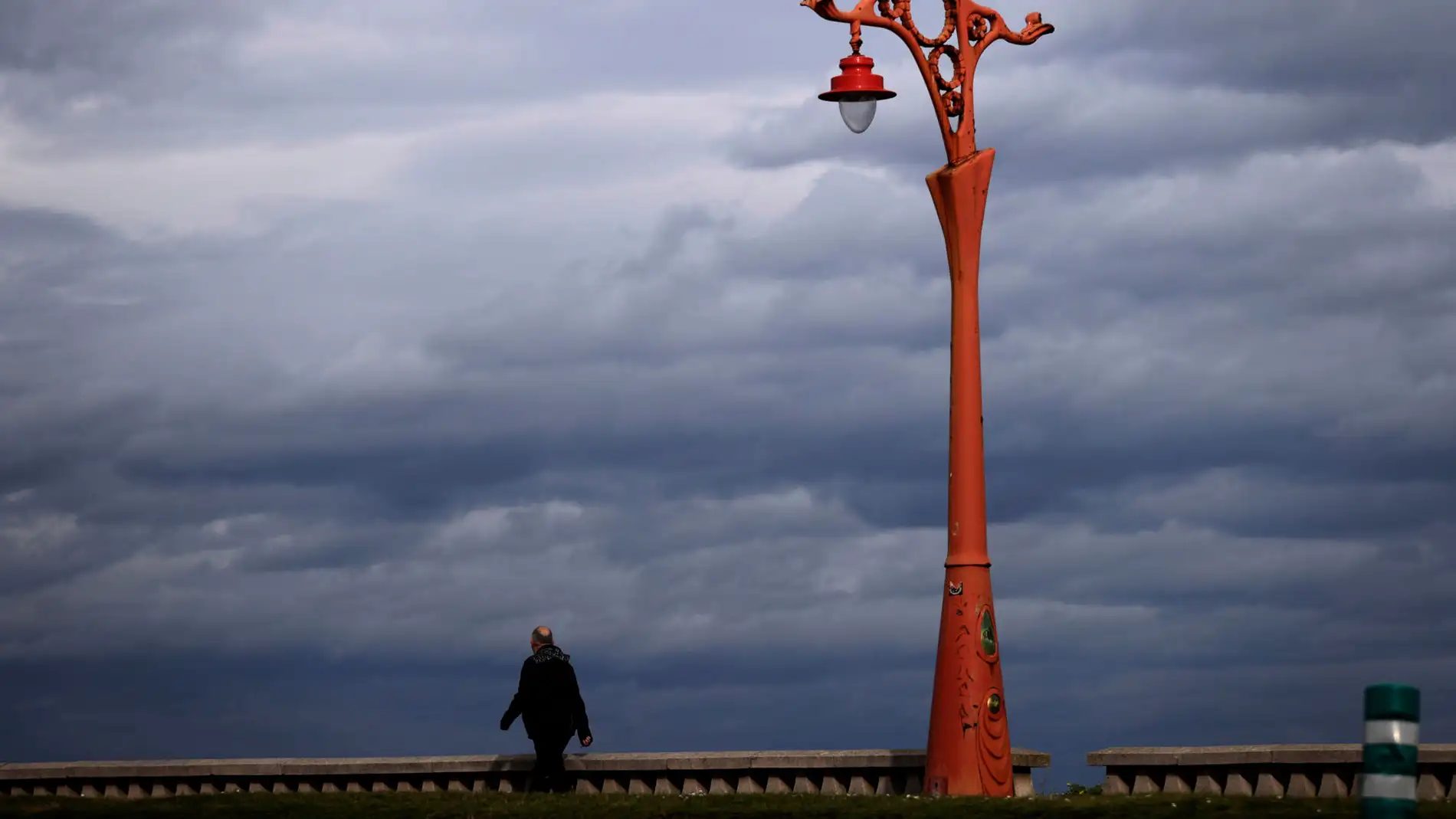 Un hombre camina por el paseo marítimo de A Coruña
