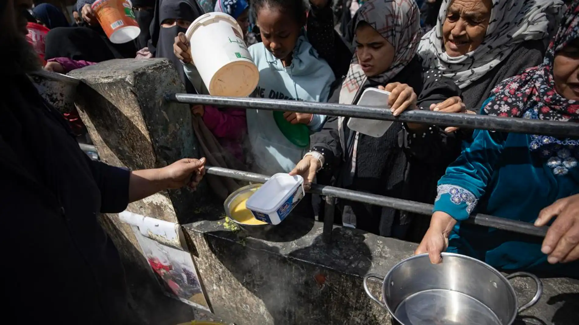 Palestinos desplazados internos sostienen cuencos vacíos mientras hacen fila para recibir ayuda alimentaria en el campo de refugiados de Rafah, en el sur de la Franja de Gaza, el 7 de marzo de 2024.