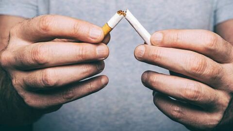 Una persona rompe por la mitad un cigarro