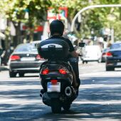 Un hombre circula en su moto por una calle de Madrid.