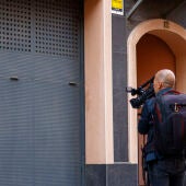 Un operador de TV toma imágenes ante la vivienda donde se produjeron los hechos precintada por la policía.