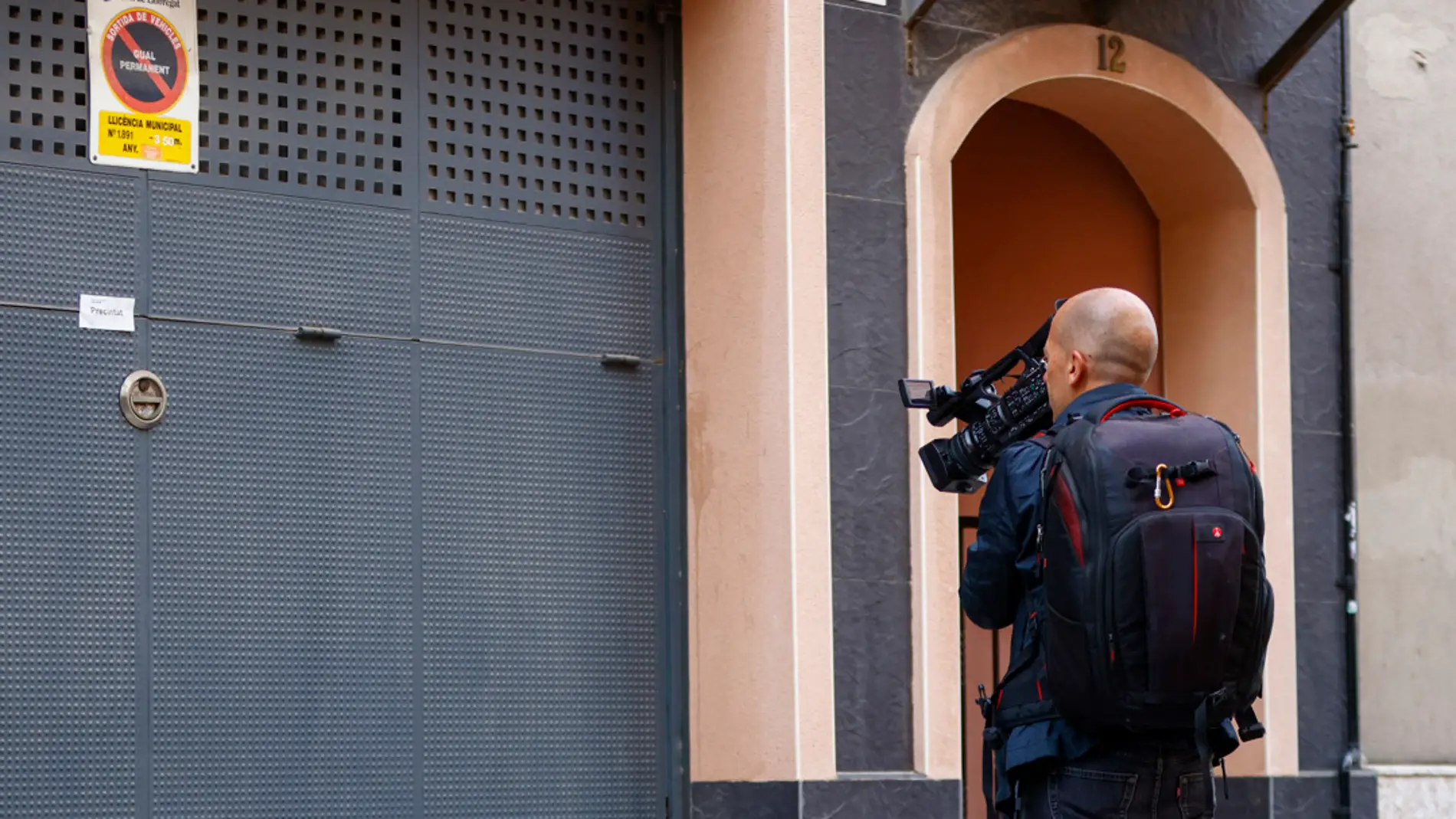 Un operador de TV toma imágenes ante la vivienda donde se produjeron los hechos precintada por la policía/ EFE/ Quique García