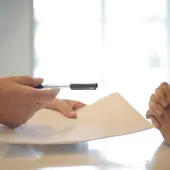 Dos personas que van a firmar un documento | Foto de archivo Dos personas que van a firmar un documento | Foto de archivo