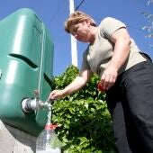 Una vecina coge agua de un depósito instalado en la plaza de su pueblo. 