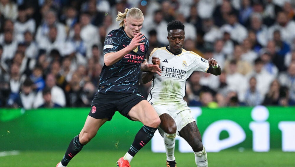 Erling Haaland y Vinicius JR disputando un balón en el Real Madrid - Manchester City