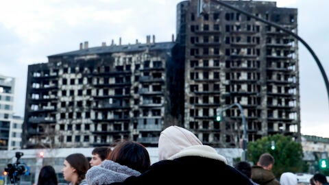 Una pareja observa abrazada el edificio incendiado en el barrio de Campanar de València. 