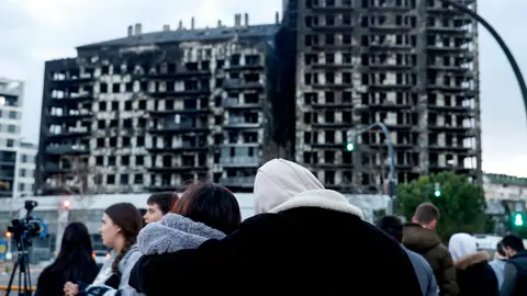 Una pareja observa abrazada el edificio incendiado en el barrio de Campanar de València. Una pareja observa abrazada el edificio incendiado en el barrio de Campanar de València.