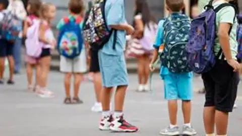 Unos alumnos esperan en el patio entrar a clase en un día lectivo Unos alumnos esperan en el patio entrar a clase en un día lectivo