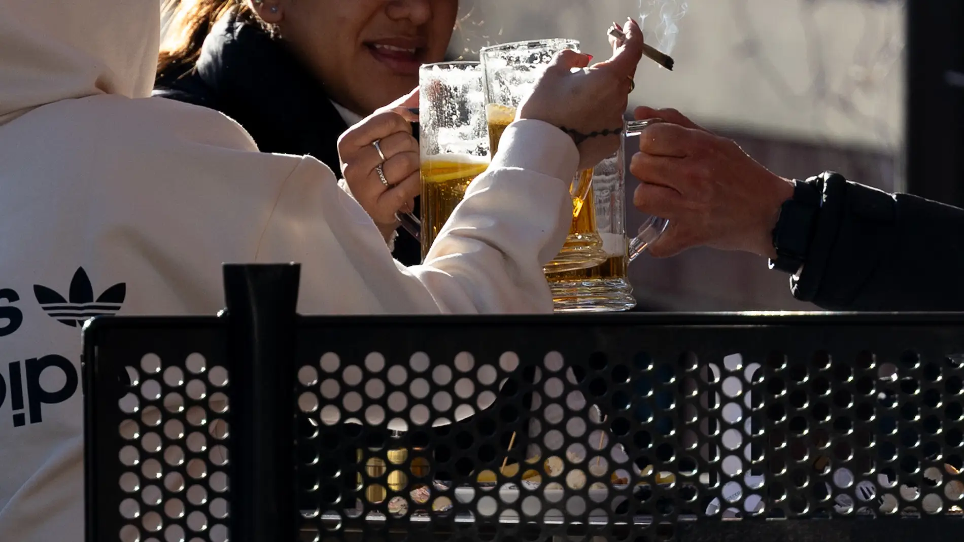Imagen de archivo de varios jóvenes consumiendo cervezas y tabaco en una terraza