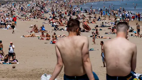 Cientos de personas disfrutan de las altas temperaturas en la playa de la Malvarrosa de Valencia, este viernes. Cuándo llegará el calor: la lluvia y el frío darán paso a un "subidón térmico"