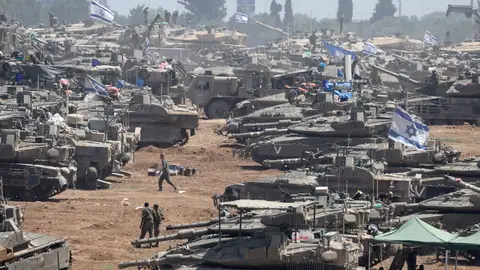 Soldados israelíes junto a sus vehículos militares se reúnen en una posición no revelada cerca de la valla fronteriza con la Franja de Gaza, en el sur de Israel. Israel ordena la evacuación de más zonas del este de Rafah y de áreas del norte de Gaza