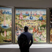 Imagen de una persona viendo de cerca el cuadro de El Bosco 'El Jardín de las Delicias'