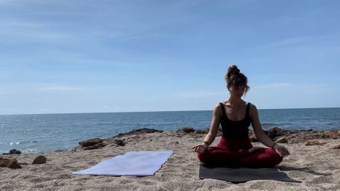 Adriana Sanz, haciendo yoga en la playa. 