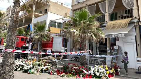 Coronas de flores y velas recuerdan a las v&iacute;ctimas del derrumbe del restaurante 'Medusa Beach Club', en la Playa de Palma