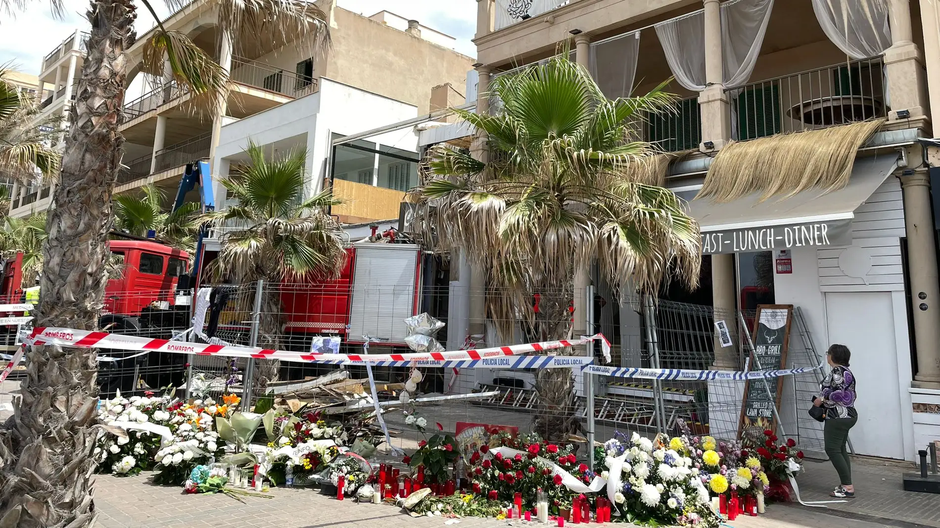 Coronas de flores y velas recuerdan a las víctimas del derrumbe del restaurante 'Medusa Beach Club', en la Playa de Palma