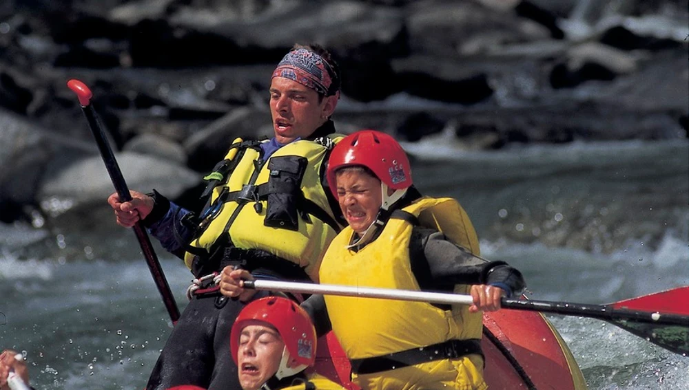 Un grupo de personas practicando rafting en aguas bravas en el río Noguera Pallaresa Un grupo de personas practicando rafting en aguas bravas en el río Noguera Pallaresa