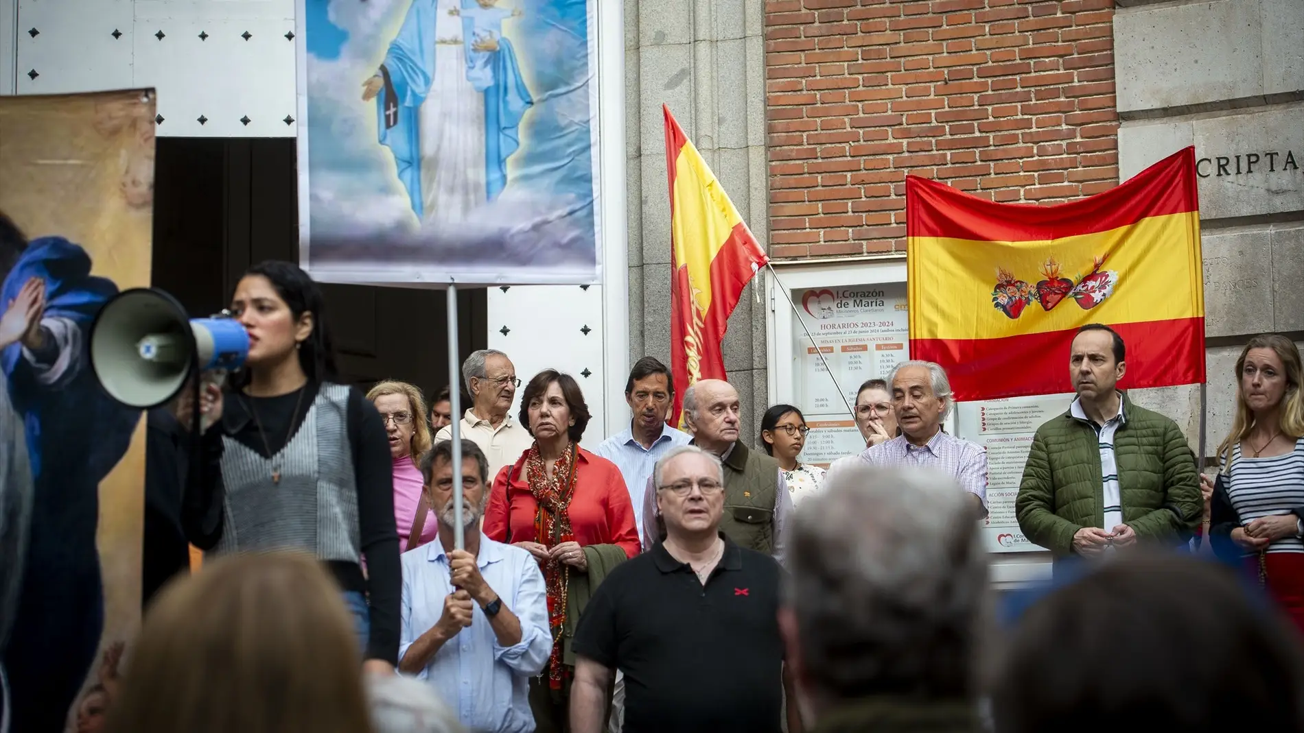 Varias personas durante una concentración para rezar colectivamente el rosario, a las puertas de la iglesia del Inmaculado Corazón de María en Madrid.