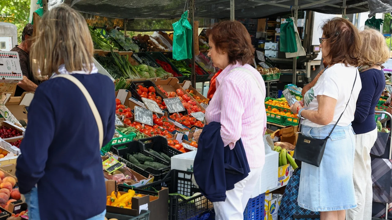 Varias personas esperan en un mercado de la Comunidad de Madrid