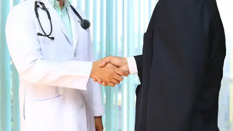 Foto de médico y administrativo Foto de médico y administrativo