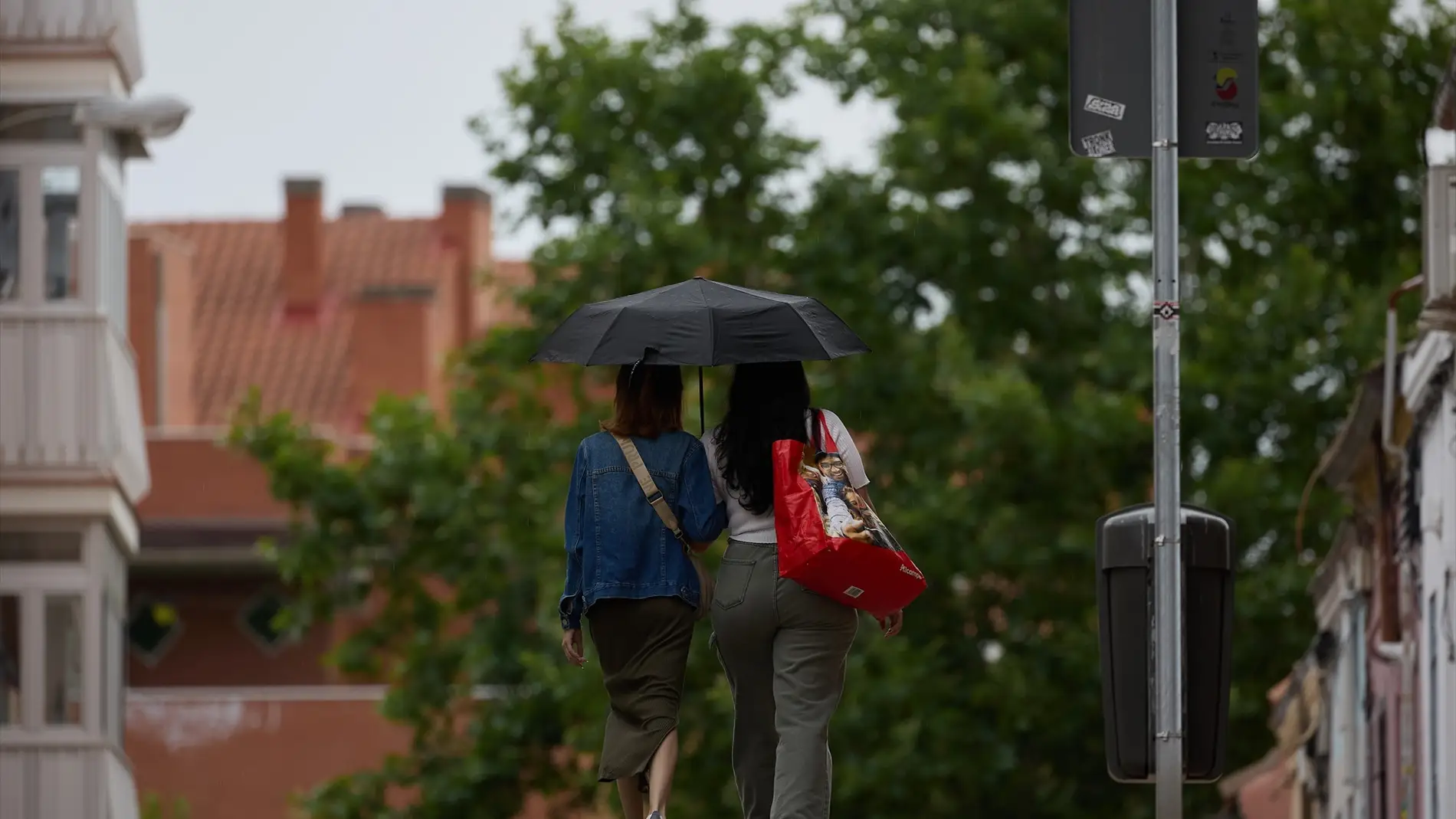 Dos mujeres se protegen de la lluvia con un paraguas.