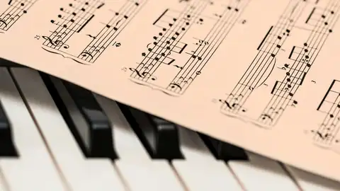 Una partitura de música sobre un piano Una partitura de música sobre un piano