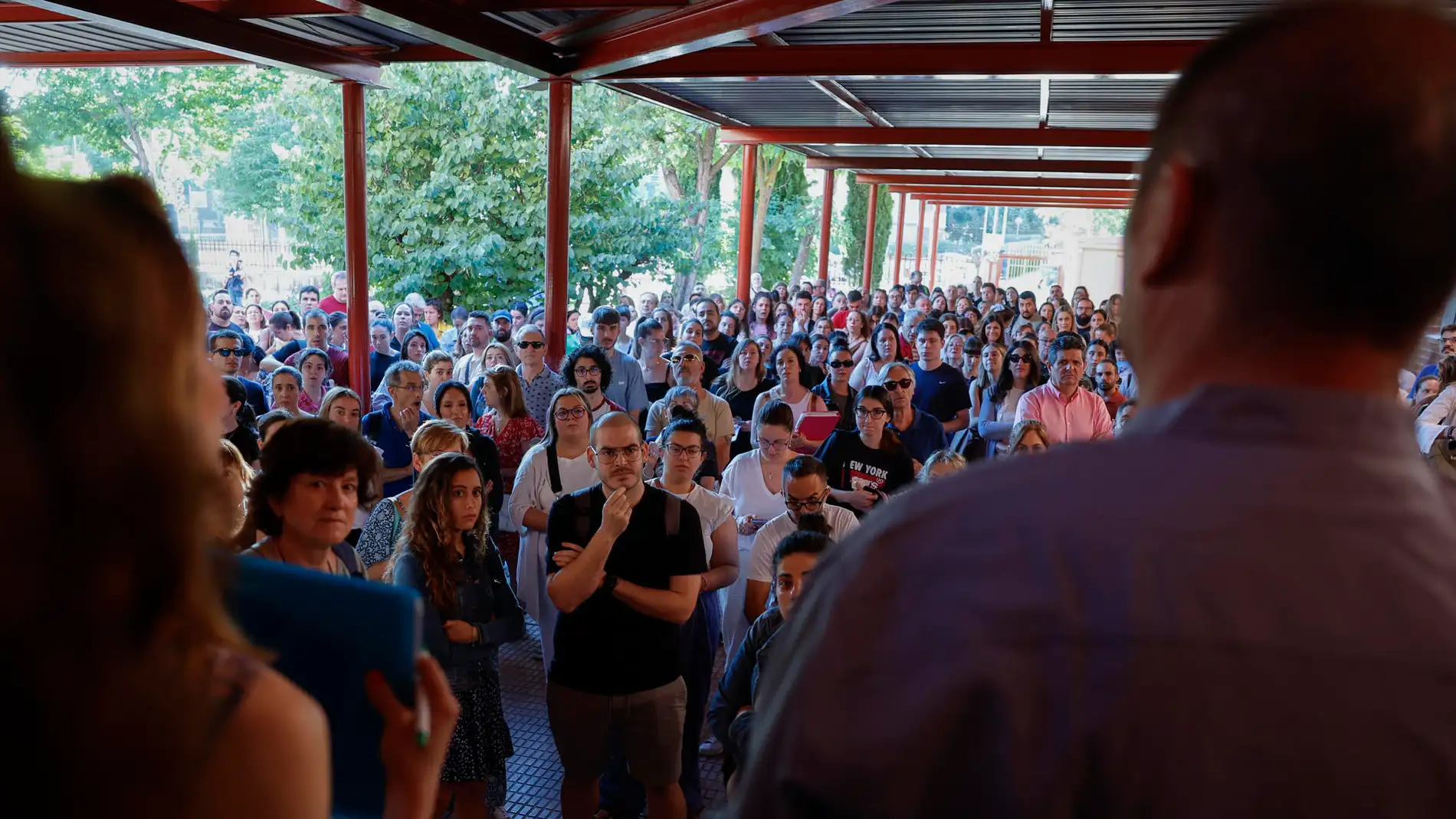 Varias personas esperan a las puertas del IES África en Fuenlabarada, Madrid, momentos antes de comenzar sus exámenes de oposición a maestros y profesores de secundaria