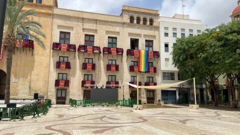 Bandera arcoíris desplegada este año 2024 en uno de los balcones laterales de la fachada del Ayuntamiento de Elche. 