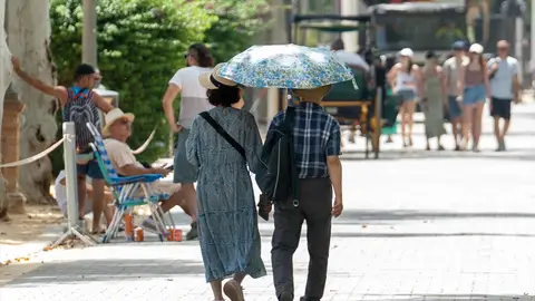 Una pareja pasea por las calles de Sevilla en plena ola de calor Los médicos de familia alertan: el calor provoca síntomas que pueden confundirse con malestar cotidiano