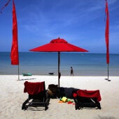 KOH PHANGAN, TAILANDIA - 18 DE JUNIO: Una playa de arena blanca decorada con sombrillas rojas en el resort Anantara Rasananda el 18 de junio de 2012 en la isla de Koh Phangan, frente a la costa de Koh Samui. El organismo oficial de turismo de Tailandia, la Autoridad de Turismo de Tailandia (TAT), se ha fijado el ambicioso objetivo de atraer a más de 20 millones de turistas en 2012. Según TAT, en abril, Tailandia recibió a 1,659,021 turistas internacionales, lo que representa un ligero aumento del 6.87% con respecto al mismo periodo en 2011. (Foto por Paula Bronstein/Getty Images)