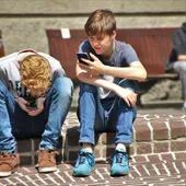 Dos niños revisando los teléfonos móviles Dos niños revisando los teléfonos móviles