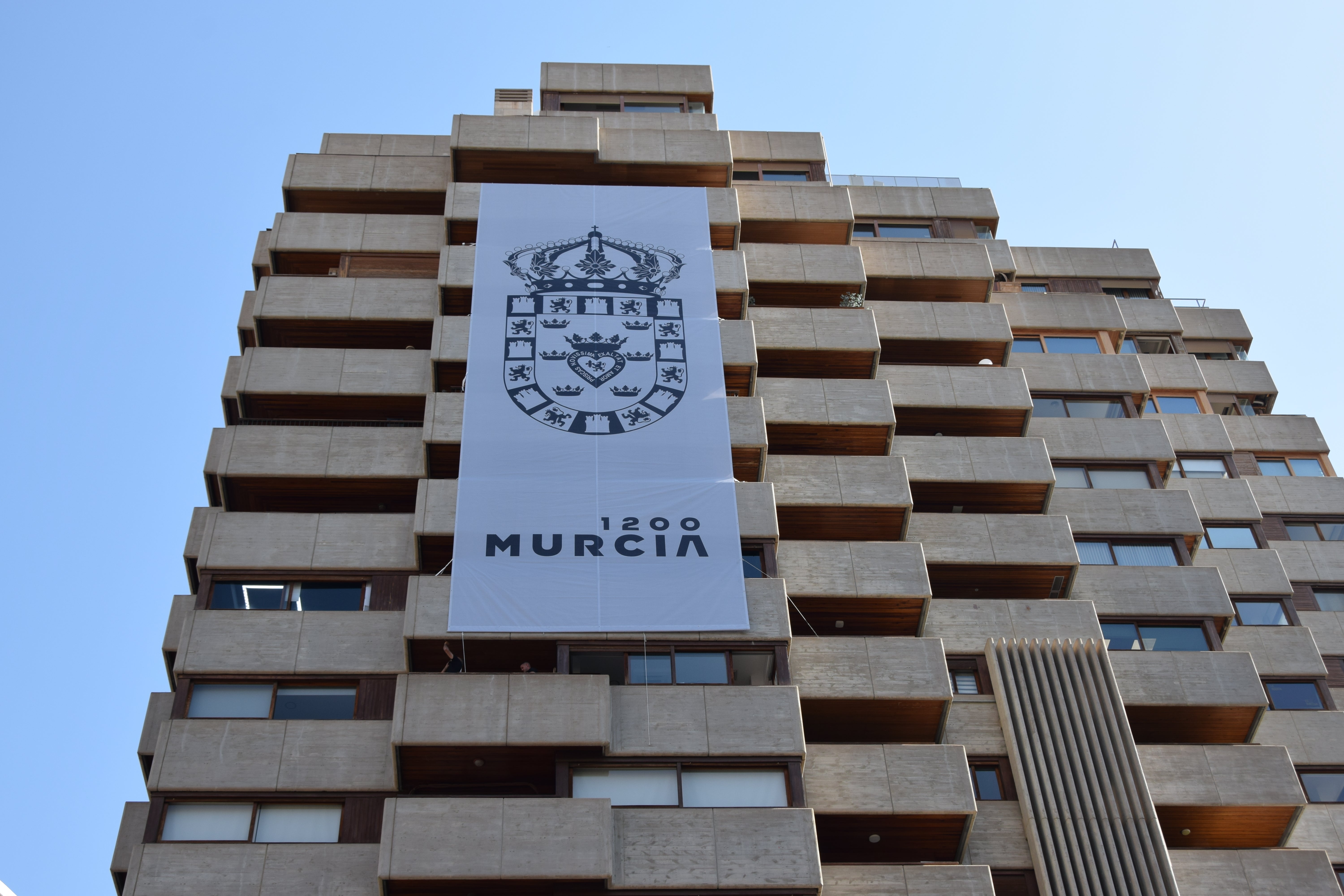 Una gran lona desplegada en el edificio Hispania de Murcia conmemora el 1.200 aniversario de la ciudad Una gran lona desplegada en el edificio Hispania de Murcia conmemora el 1.200 aniversario de la ciudad
