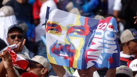 Un simpatizante sostiene un cartel con la imagen del presidente de Venezuela y aspirante a la reelección, Nicolás Maduro, durante el cierre de su campaña Venezuela reflexiona mientras miles de ojos vigilan que el chavismo no haga trampa electoral