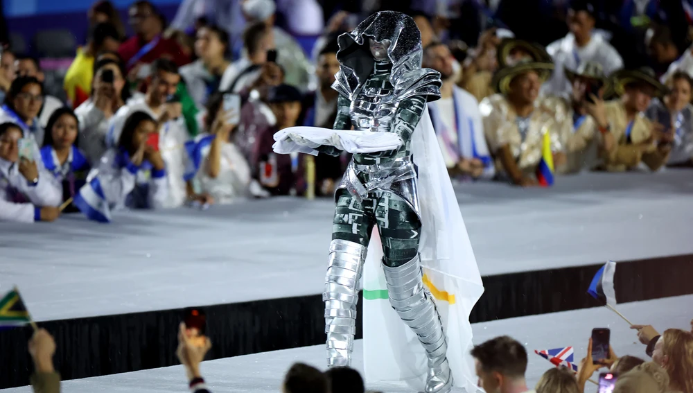 La jinete sostiene la bandera olímpica antes del izado. La jinete sostiene la bandera olímpica antes del izado.