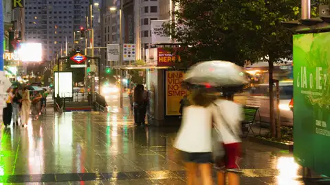 Imagen de archivo de una pareja paseando por Madrid bajo la lluvia Una fuerte tromba de agua sorprende Madrid y provoca inundaciones y cortes en Metro y Cercanías