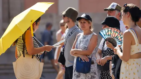 Un grupo de personas se protege del calor con parasol, abanico y gorras en la ciudad de València. Un grupo de personas se protege del calor con parasol, abanico y gorras en la ciudad de València.