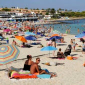 Turistas disfrutando de la playa de Punta Prima, Sant Lluís. 