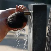 Una persona bebe agua ante el intenso calor Una persona bebe agua ante el intenso calor