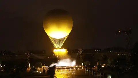 El pebetero se eleva en el aire enganchado a un globo aerostático durante la ceremonia de inauguración de los Juegos Olímpicos de París 2024. El pebetero se eleva en el aire enganchado a un globo aerostático durante la ceremonia de inauguración de los Juegos Olímpicos de París 2024.