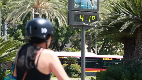 Una joven se resguarda del sol con un abanico para soportar las altas temperaturas. Una joven se resguarda del sol con un abanico para soportar las altas temperaturas.