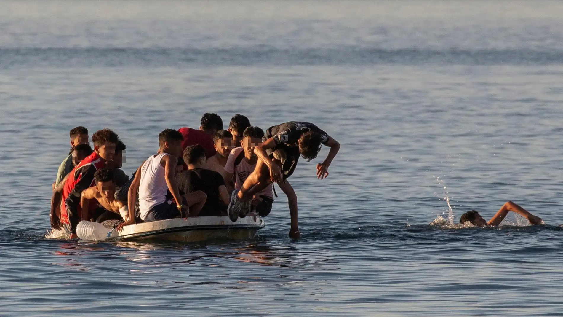 Imagen de archivo de varios menores migrantes lanzándose al agua para alcanzar la playa ceutí de El Tarajal Imagen de archivo de varios menores migrantes lanzándose al agua para alcanzar la playa ceutí de El Tarajal