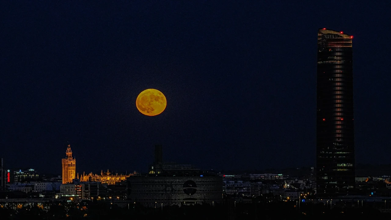 La luna de Esturión sale por detrás de la Giralda y la Catedral a 01 de agosto del 2023 en Sevilla.