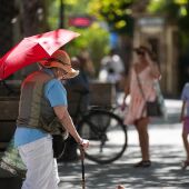 Imagen de archivo de una mujer con sombrero y sombrilla paseando por puerta de Jerez.