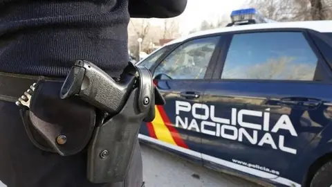 Imagen de archivo de un agente y un coche de la Policía Nacional. Imagen de archivo de un agente y un coche de la Policía Nacional.