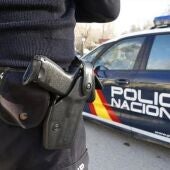 Imagen de archivo de un agente y un coche de la Policía Nacional.