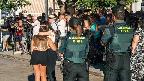 Dos agentes de la Guardia Civil observan a dos niñas abrazarse durante el minuto de silencio por el asesinato de un menor, en la puerta del Ayuntamiento de Mocejón. Dos agentes de la Guardia Civil observan a dos niñas abrazarse durante el minuto de silencio por el asesinato de un menor, en la puerta del Ayuntamiento de Mocejón.
