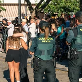 Dos agentes de la Guardia Civil observan a dos niñas abrazarse durante el minuto de silencio por el asesinato de un menor, en la puerta del Ayuntamiento de Mocejón. Dos agentes de la Guardia Civil observan a dos niñas abrazarse durante el minuto de silencio por el asesinato de un menor, en la puerta del Ayuntamiento de Mocejón.